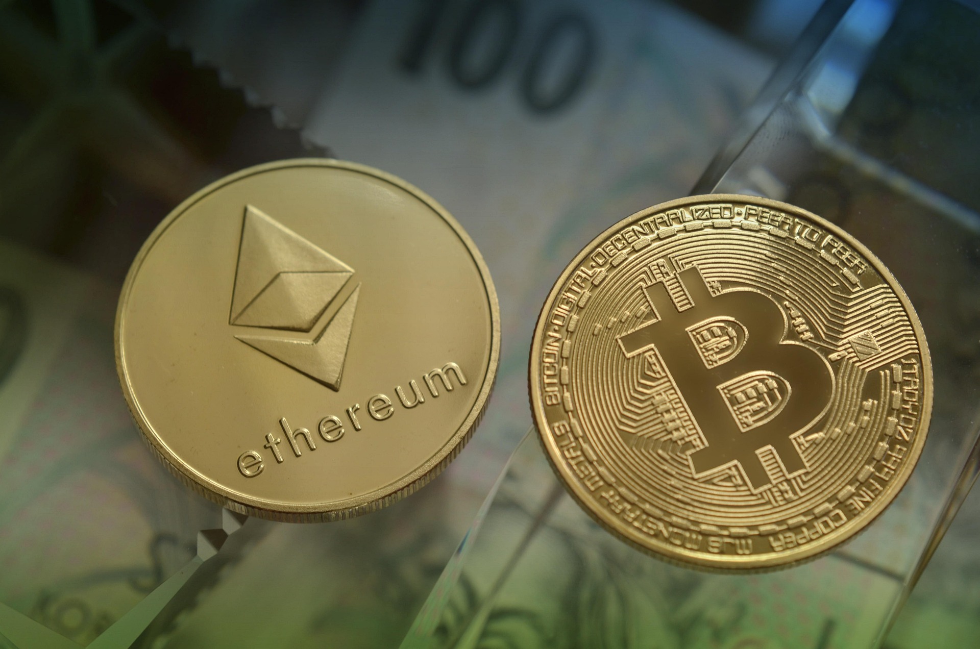 Close-up of gold Ethereum and Bitcoin coins placed side by side, symbolizing cryptocurrency trading, blockchain technology, and digital finance.